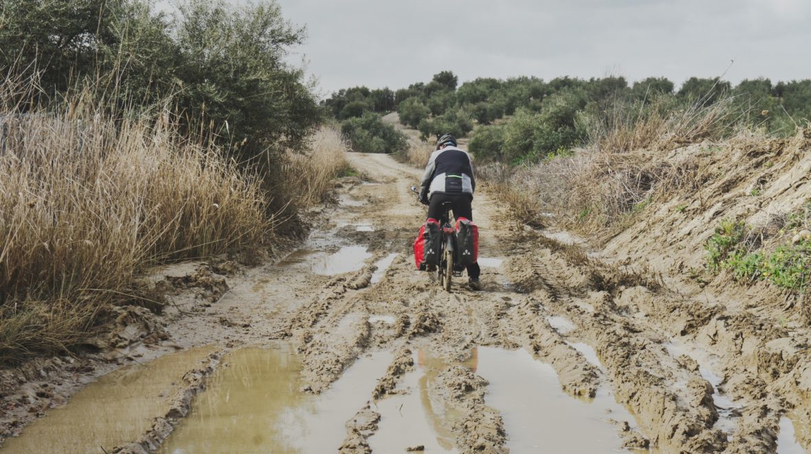 Jérôme à vélo sur un chemin très boueux d'Andalousie